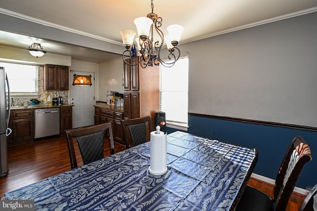 dining area with a notable chandelier, dark hardwood / wood-style floors, and ornamental molding