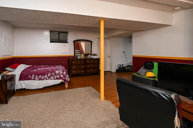 bedroom featuring wood-type flooring and a textured ceiling