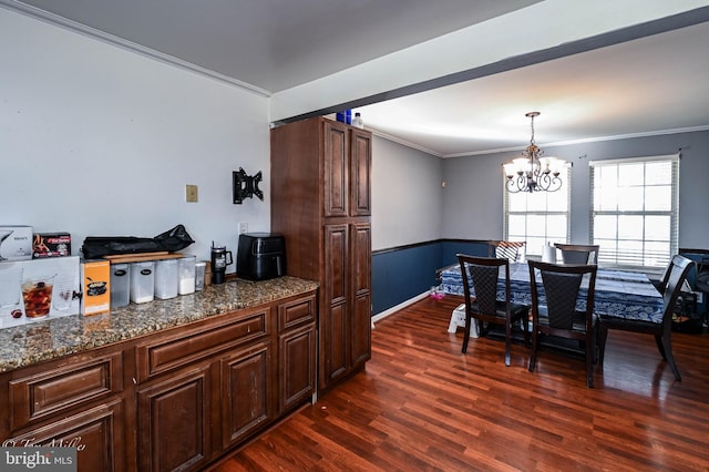 dining room with ornamental molding, dark wood-type flooring, and a notable chandelier