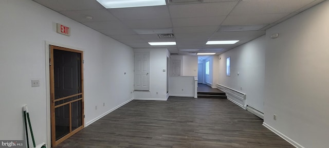 spare room featuring a paneled ceiling, dark hardwood / wood-style flooring, and a baseboard radiator