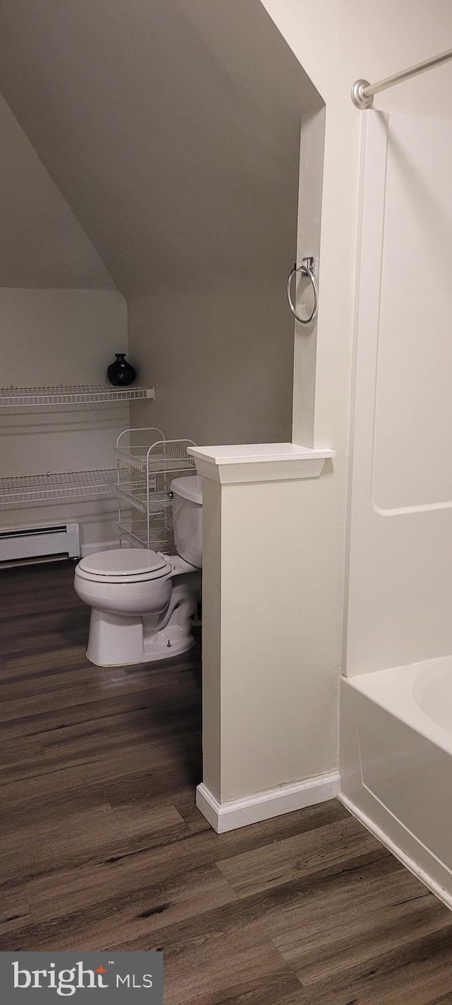 bathroom featuring wood-type flooring, toilet, baseboard heating, and tub / shower combination