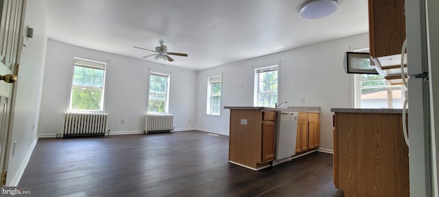 kitchen featuring plenty of natural light, white appliances, and radiator