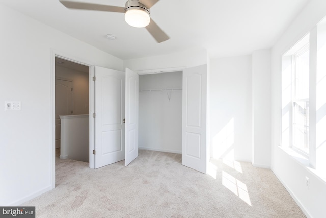 unfurnished bedroom featuring ceiling fan, light colored carpet, and a closet