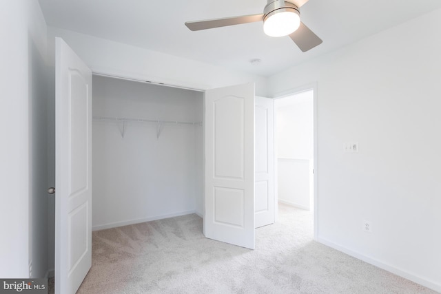 unfurnished bedroom with ceiling fan, light carpet, and a closet