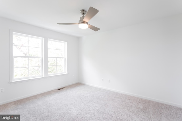 carpeted spare room featuring ceiling fan