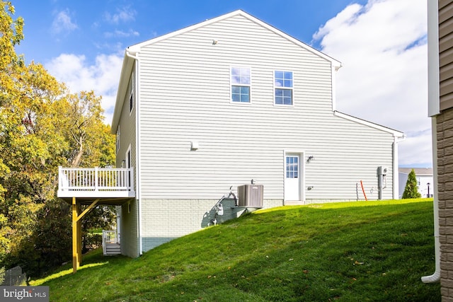 back of house with a lawn and central AC unit