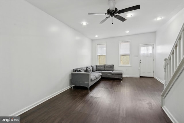 unfurnished living room with ceiling fan and dark wood-type flooring