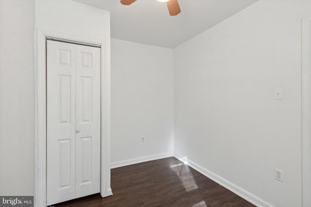 unfurnished bedroom with a closet, dark hardwood / wood-style floors, and ceiling fan