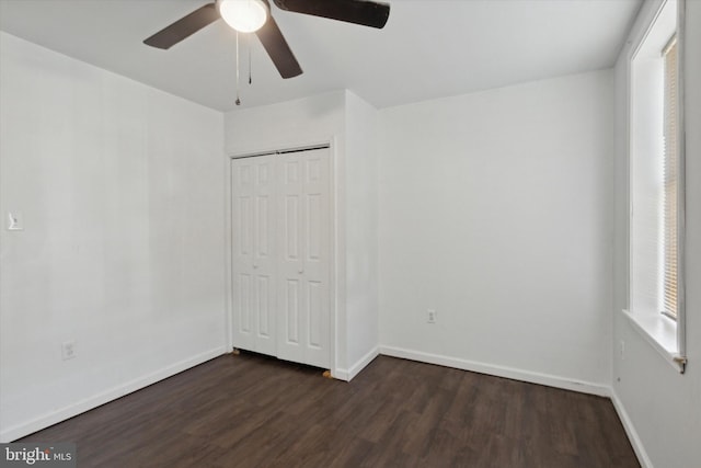 unfurnished bedroom featuring a closet, dark hardwood / wood-style floors, and ceiling fan