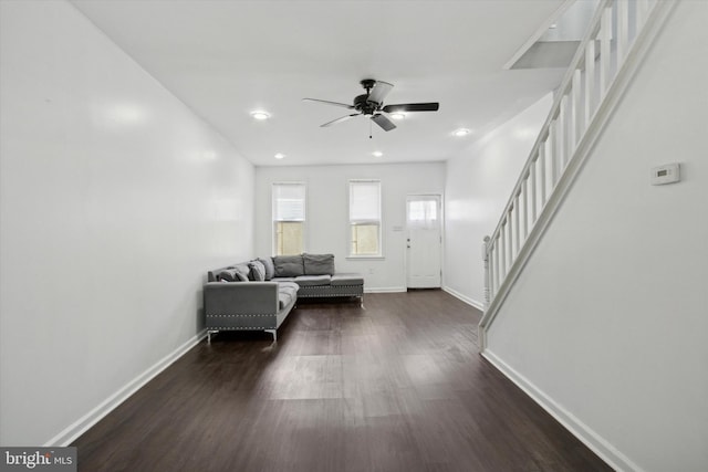 unfurnished living room with ceiling fan and dark wood-type flooring