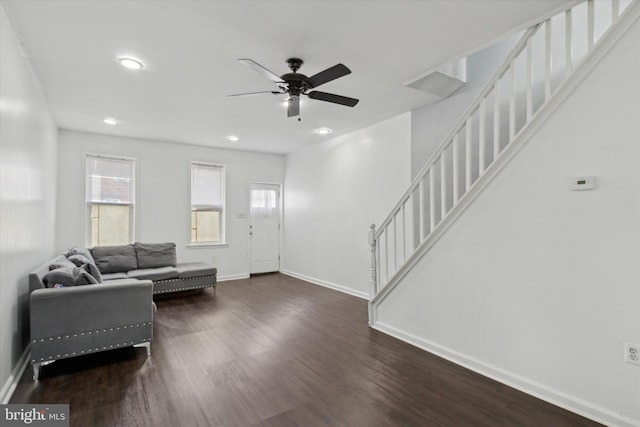 living room featuring ceiling fan and dark hardwood / wood-style floors