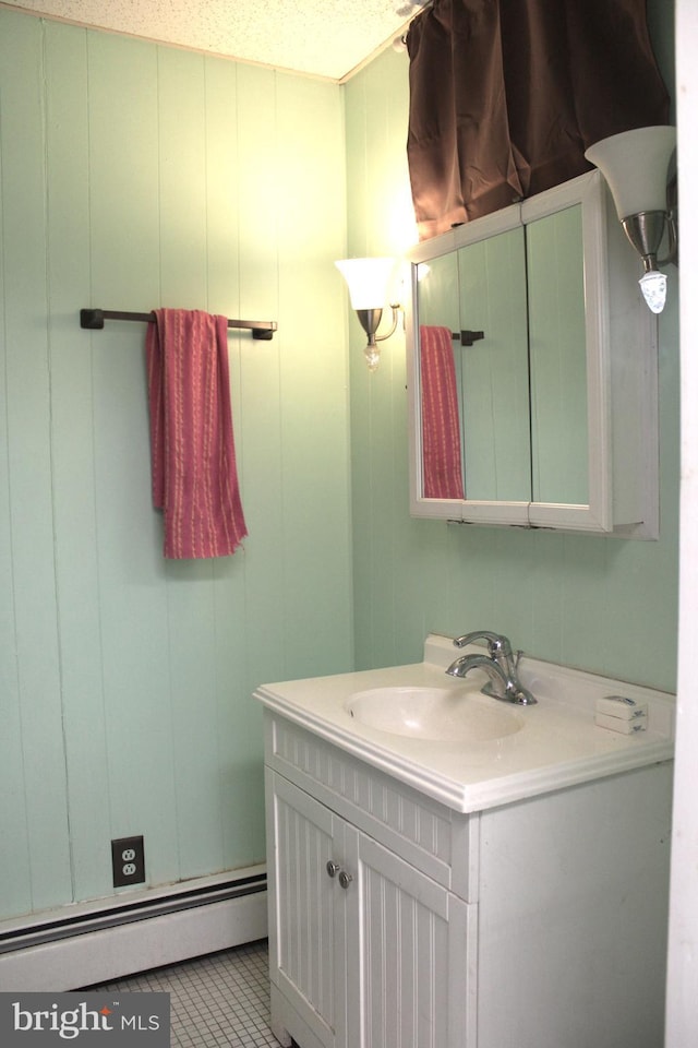 bathroom with tile patterned flooring, vanity, a textured ceiling, and a baseboard radiator