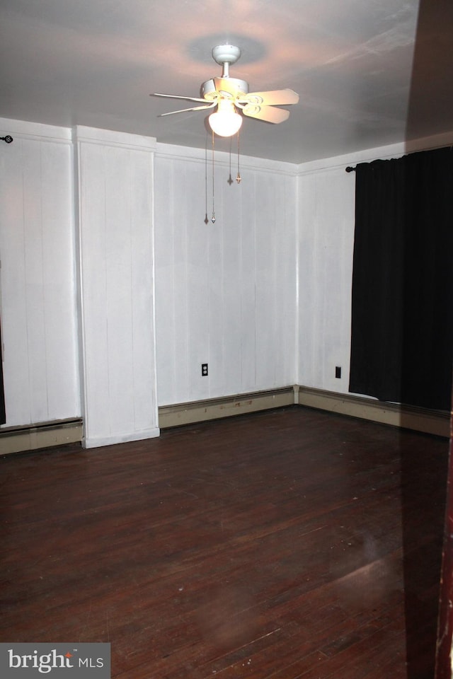 spare room with ceiling fan, dark hardwood / wood-style flooring, and a baseboard radiator