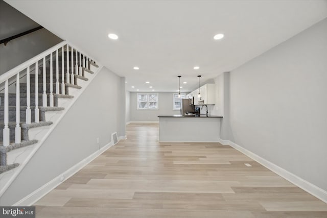 interior space with light hardwood / wood-style floors and sink