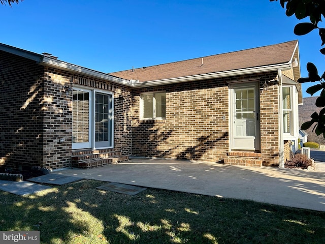 view of exterior entry with a patio area and a yard