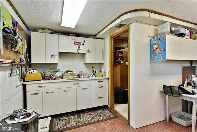 kitchen with white cabinets and a textured ceiling