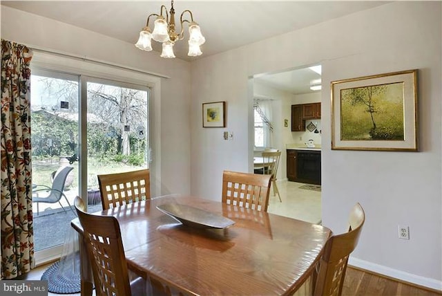 dining area with light hardwood / wood-style floors and a chandelier