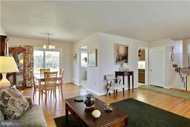 living room with light hardwood / wood-style floors and an inviting chandelier