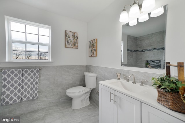 bathroom with vanity, tile walls, and toilet