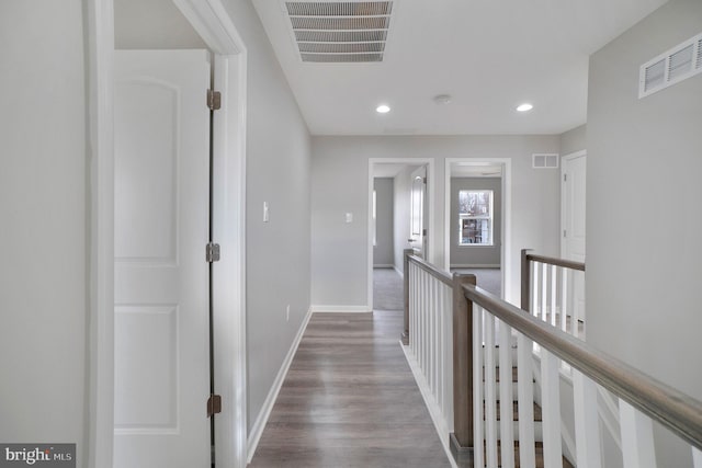 hallway with recessed lighting, wood finished floors, visible vents, and baseboards