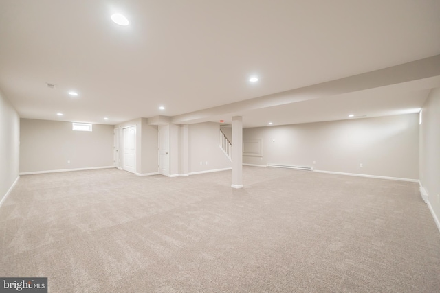 finished below grade area with baseboards, a baseboard radiator, light carpet, and recessed lighting