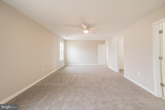 spare room with a ceiling fan, carpet, and baseboards