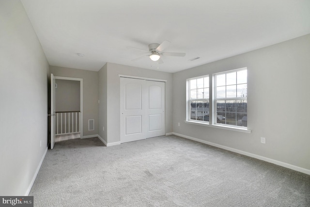 unfurnished bedroom featuring visible vents, baseboards, a ceiling fan, carpet, and a closet