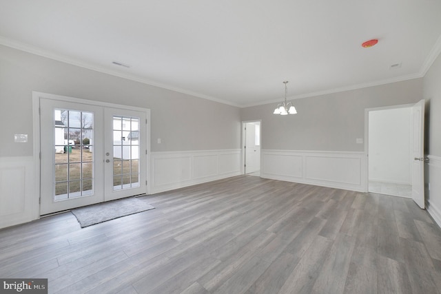 unfurnished room featuring french doors, light hardwood / wood-style floors, and ornamental molding