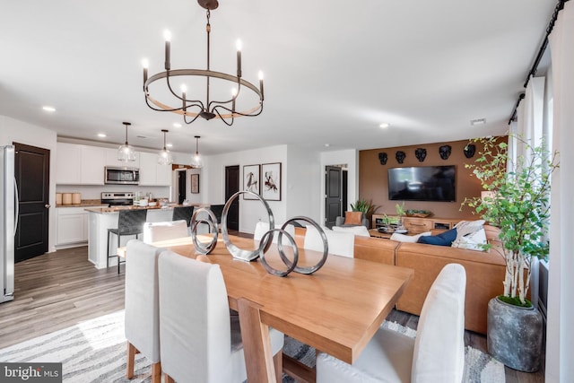 dining space featuring a notable chandelier and light wood-type flooring