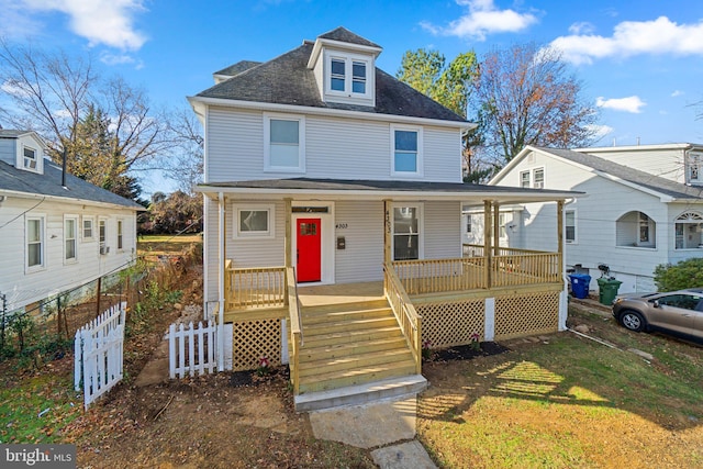 view of property with covered porch and a front yard