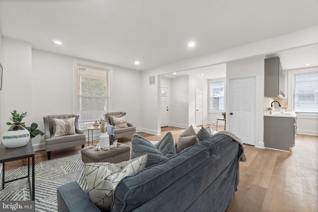 living room with sink and light hardwood / wood-style flooring