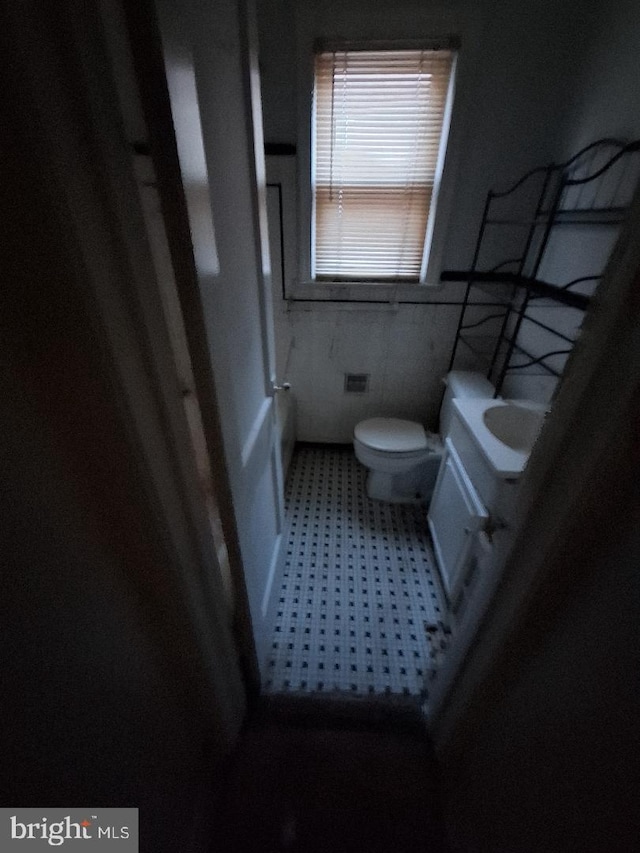 bathroom with vanity, tile walls, and toilet