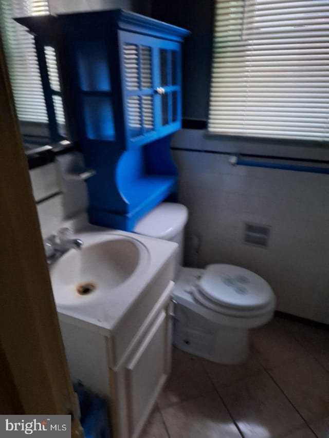 bathroom featuring tile patterned flooring, vanity, and toilet