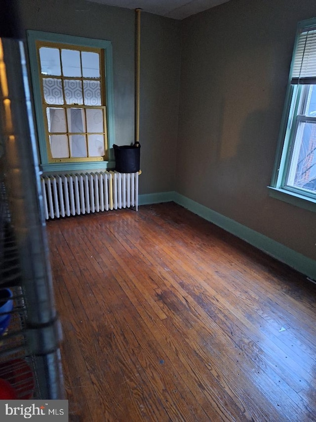 spare room with wood-type flooring and radiator