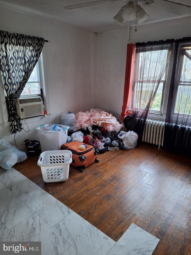 living room featuring radiator, wood-type flooring, and a textured ceiling