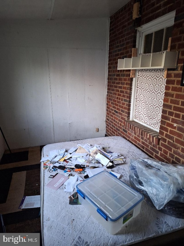 bedroom featuring brick wall