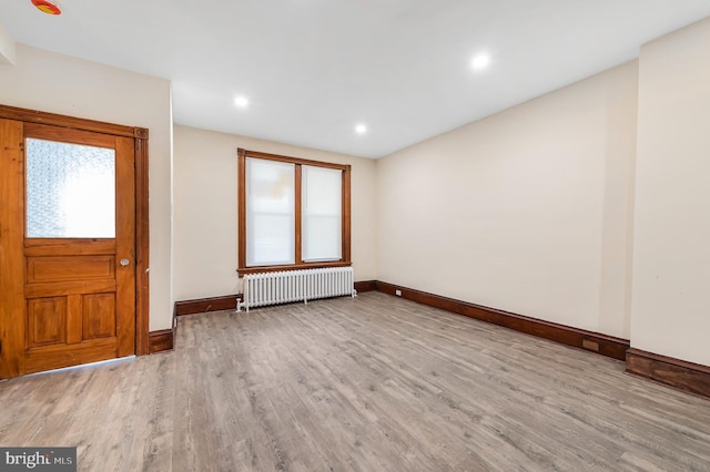 entryway featuring radiator heating unit, light hardwood / wood-style floors, and a wealth of natural light