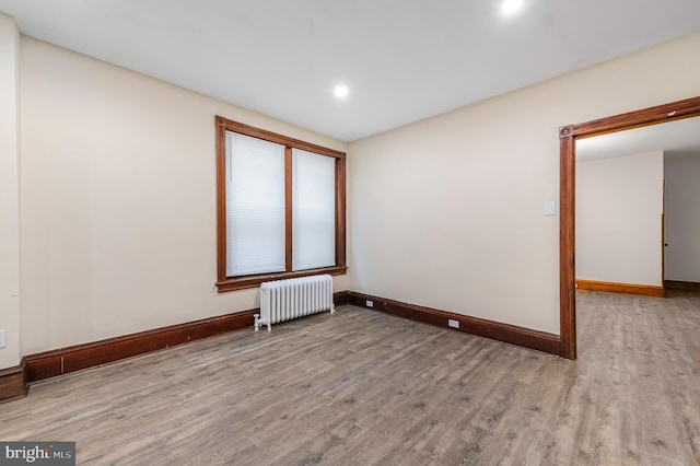 unfurnished room featuring light wood-type flooring and radiator