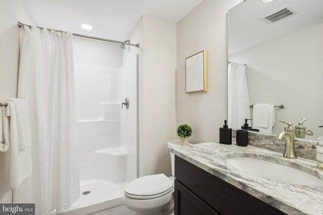 bathroom featuring a shower with shower curtain, vanity, and toilet