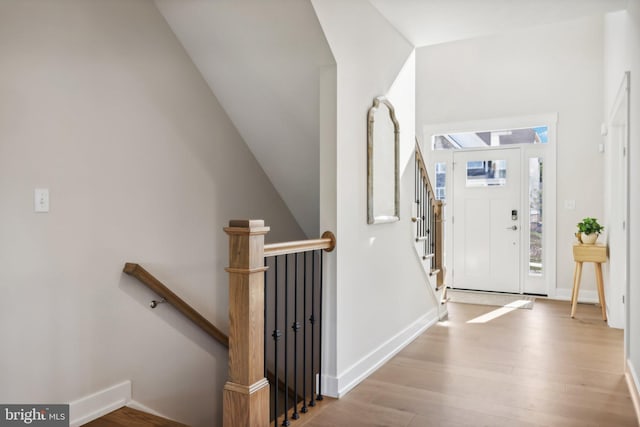 foyer entrance featuring light wood-type flooring and vaulted ceiling