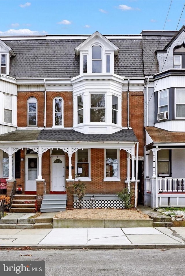 townhome / multi-family property with cooling unit and covered porch