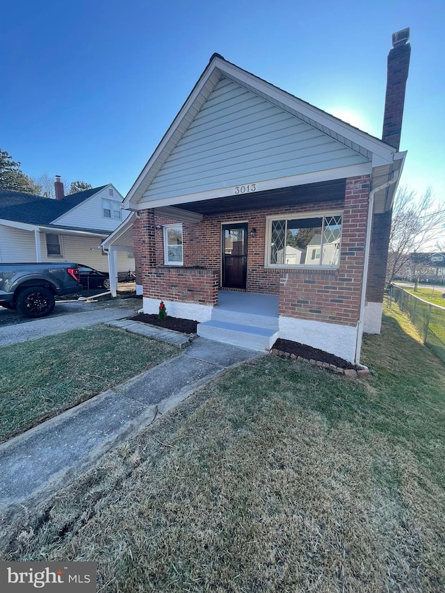 view of front of house with a front yard and covered porch