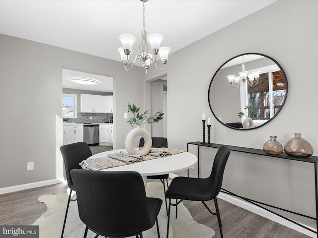 dining area featuring wood-type flooring and an inviting chandelier