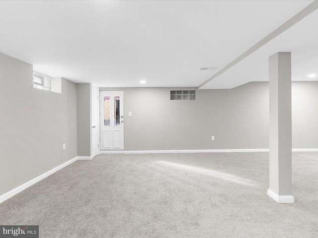 basement featuring light carpet