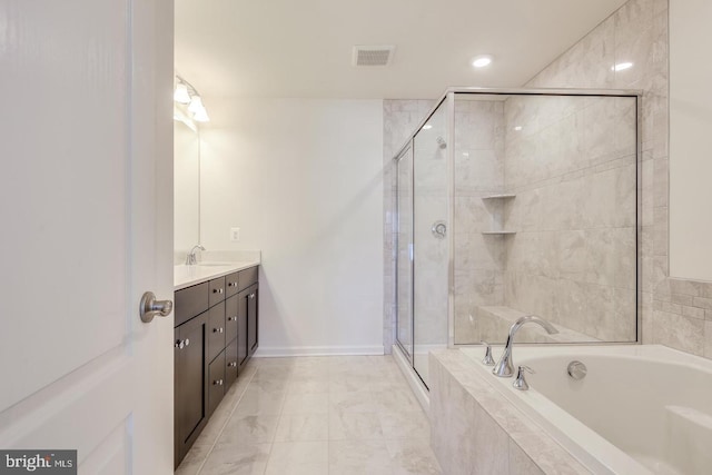 bathroom featuring vanity and independent shower and bath