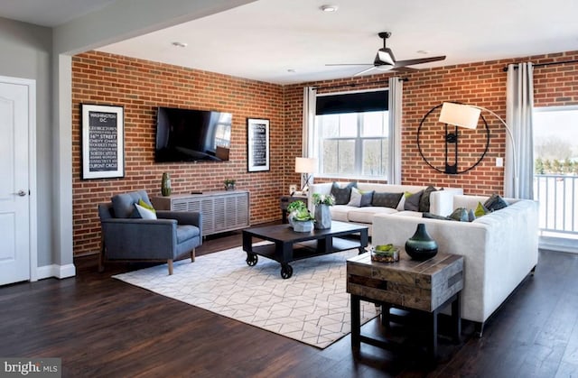 living room with ceiling fan, brick wall, and hardwood / wood-style flooring