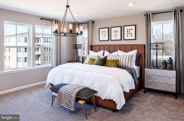 carpeted bedroom with an inviting chandelier