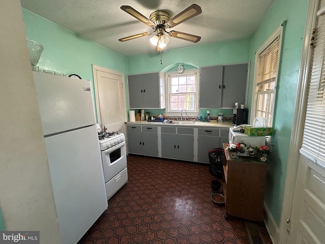 kitchen featuring ceiling fan, white appliances, and sink