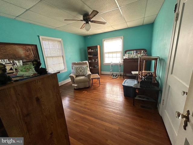 sitting room featuring dark hardwood / wood-style flooring, ceiling fan, and a paneled ceiling