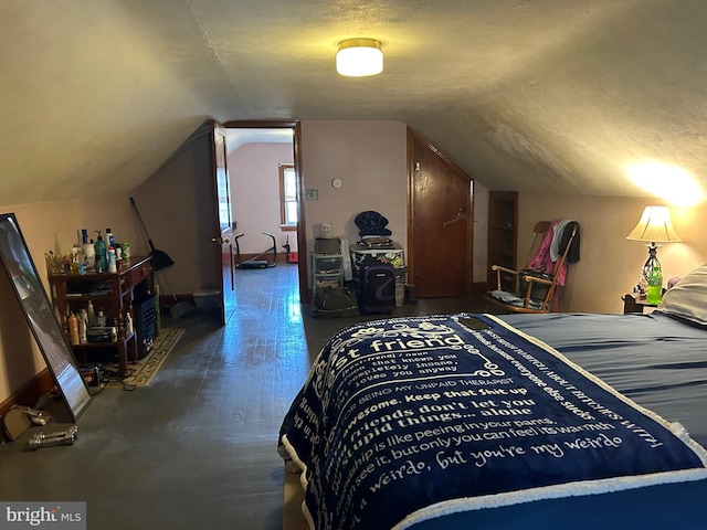 bedroom with dark hardwood / wood-style flooring, a textured ceiling, and vaulted ceiling